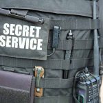 Secret Service vest with various tactical gear attached.