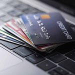 Stack of credit cards on a laptop keyboard.