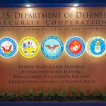 U.S. Department of Defense Security Cooperation display with logos.