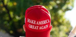 Red "Make America Great Again" hat on person's head.