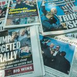 Newspaper headlines about Trump assassination attempt news.