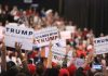 Crowd holding signs supporting Trump at a rally.