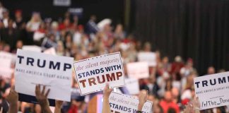 Crowd holding signs supporting Trump at a rally.