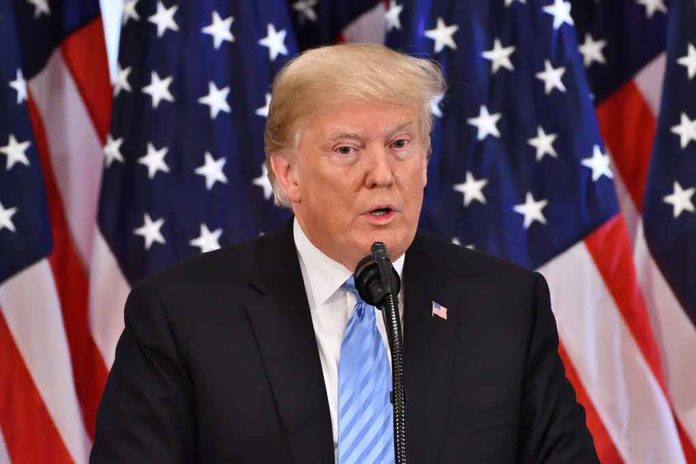 Man speaking at podium with American flags behind.