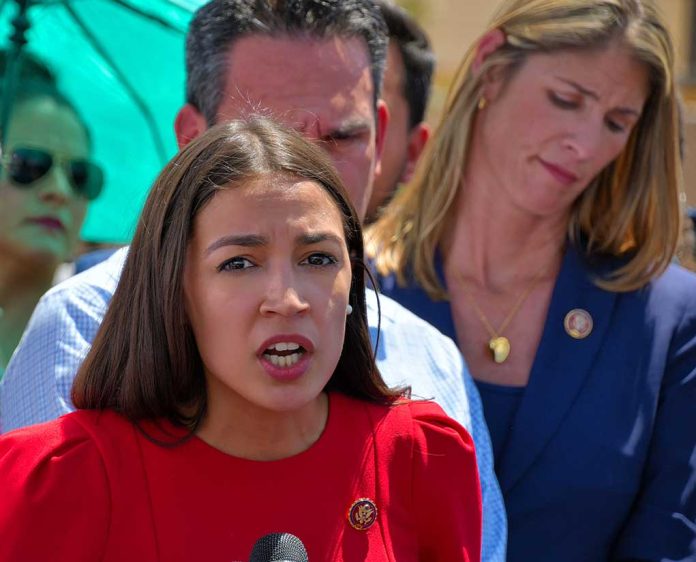 Woman in red speaking at outdoor event.