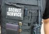 Secret Service vest with various tactical gear attached.