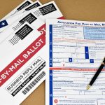 Vote-by-mail envelopes and application form with a pen.