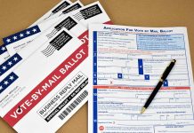 Vote-by-mail envelopes and application form with a pen.