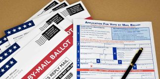 Vote-by-mail envelopes and application form with a pen.