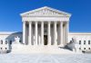 United States Supreme Court building under clear blue sky.