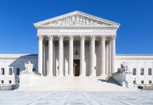 United States Supreme Court building under clear blue sky.