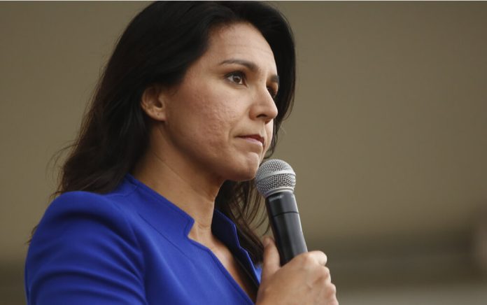 Woman in blue blazer holding a microphone.