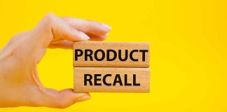 Hand holding "Product Recall" blocks on yellow background.