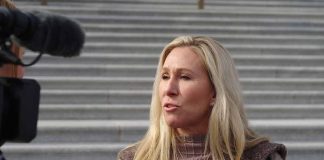 Woman speaking to a camera on building steps.