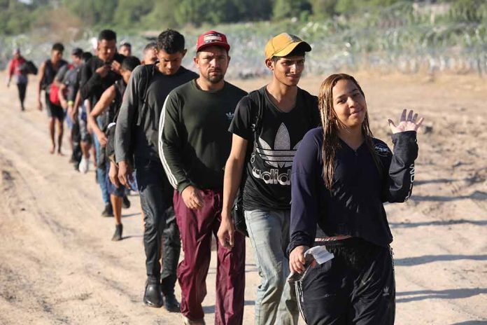 Line of people walking on a dirt road.