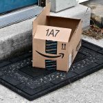 Open Amazon package on doorstep doormat.