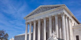 Supreme Court building with columns and statues.