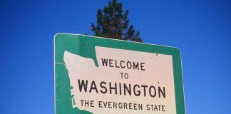 Welcome to Washington state sign under blue sky.