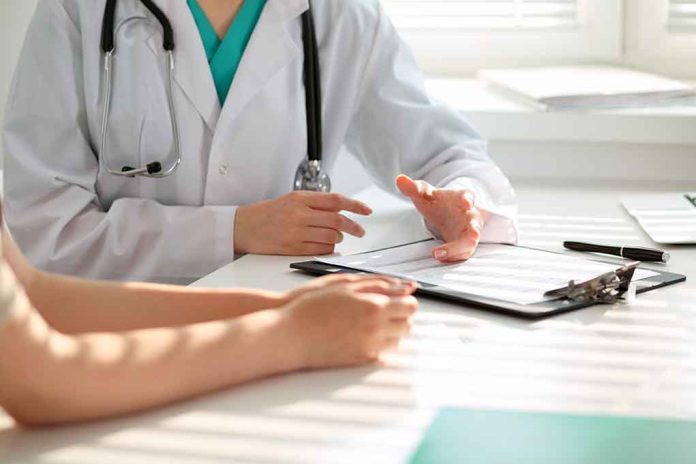 Doctor discussing with patient, holding clipboard on desk.