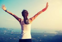 Person with arms raised overlooking a scenic view