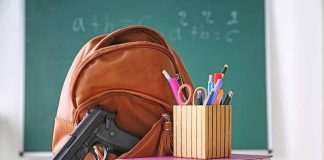 Gun and backpack on desk with school supplies.