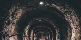 Dimly lit underground tunnel with rocky walls.