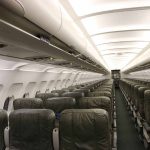 Empty airplane cabin with green seats.