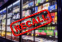 "Recall" stamp over blurred grocery store shelves.