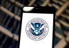 U.S. Department of Homeland Security logo on smartphone.