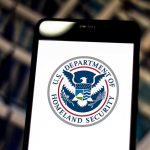 U.S. Department of Homeland Security logo on smartphone.
