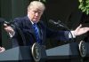 Man gesturing at two podiums outdoors.