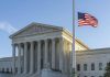 US flag flying outside a neoclassical government building
