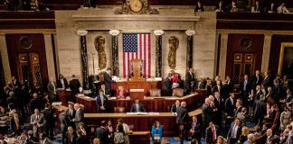 Crowded legislative chamber with people in discussion
