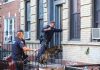 Police officers with dog entering building doorway steps