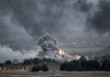 Smoke and fire rise from explosion in city landscape
