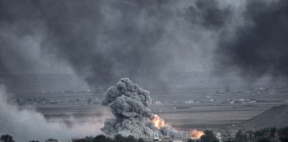 Smoke and fire rise from explosion in city landscape