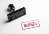 Rubber stamp with banned text on paper