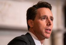 Man in suit speaking, looking to his right.