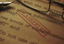 Classified document with glasses and pen closeup