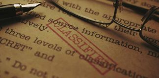 Classified document with glasses and pen closeup
