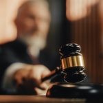Judge with gavel in courtroom setting blurred background