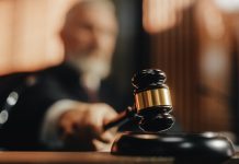 Judge with gavel in courtroom setting blurred background