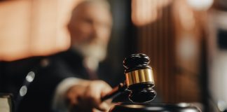 Judge with gavel in courtroom setting blurred background