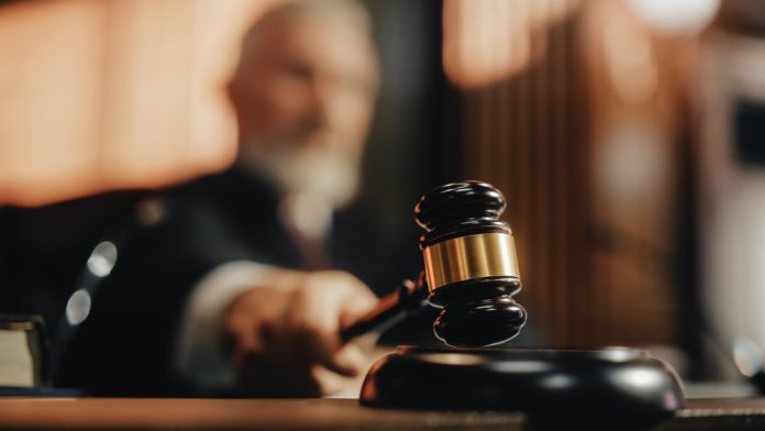 2056414424 featured image Judge with gavel in courtroom setting blurred background