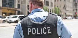 Police officer in uniform standing on city street