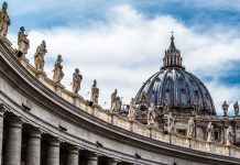 St. Peter's Basilica dome with statues and clouds