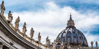 St. Peter's Basilica dome with statues and clouds