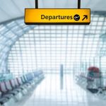 Yellow departures sign in empty airport terminal