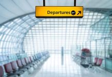 Yellow departures sign in empty airport terminal