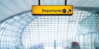 Yellow departures sign in empty airport terminal